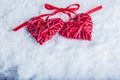 Two beautiful vintage red hearts tied together with a ribbon on a white snow background. Love and St. Valentines Day concept. Royalty Free Stock Photo