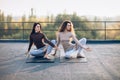 Two beautiful women doing yoga asana virabhadrasana on the roof Royalty Free Stock Photo