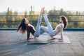 Two beautiful women doing acroyoga asana on the roof outdoors Royalty Free Stock Photo