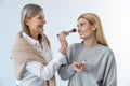 Two beautiful women doing make up and looking contented Royalty Free Stock Photo