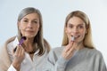 Two beautiful women doing make up and looking contented Royalty Free Stock Photo