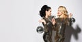 Two beautiful women, blonde and brunette in shiny dresses sing with a microphone, holding disco balls. Royalty Free Stock Photo