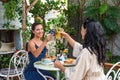 two beautiful women friends clinking lemonades for cheers and eating breakfast in cafe Royalty Free Stock Photo