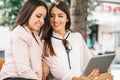 Two beautiful women laughing watching media content together in a digital tablet Royalty Free Stock Photo