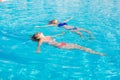 Two beautiful women lying on swimming pool water surface Royalty Free Stock Photo