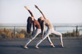 Two beautiful women perform double pose warrior with raised hand