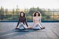 Two beautiful women perform meditative pose gomukhasana