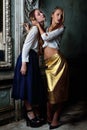 Two beautiful women posing in obsolete interior. Royalty Free Stock Photo