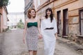 Two beautiful women walking on the street holding hands talking Royalty Free Stock Photo