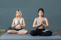 Two beautiful young asian girl are wearing workout clothes doing sitting and meditating in fitness center Royalty Free Stock Photo