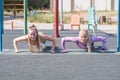 Two beautiful, young and athletic girls doing push-ups on a street playground. Royalty Free Stock Photo