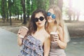 Two beautiful young boho chic stylish girls walking in park. Royalty Free Stock Photo