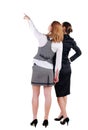 Two beautiful young bussineswoman looking at wall. Rear view. Is Royalty Free Stock Photo