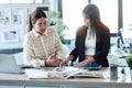 Two beautiful young designer women working in a design project while choosing materials in the office Royalty Free Stock Photo