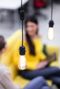 Two beautiful young female business colleagues having a meeting in an office. Decorative modern light bulb in focus Royalty Free Stock Photo