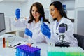 Two beautiful young female scientists working in laboratory with test tubes doing some research Royalty Free Stock Photo