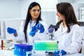 Two beautiful young female scientists working in laboratory with test tubes doing some research Royalty Free Stock Photo