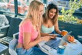 Two beautiful and young girl friends together using computer laptop at cafeteria Royalty Free Stock Photo