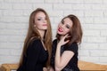 Two beautiful young girls in black dresses sit on the bench and gossip Royalty Free Stock Photo