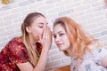 Two beautiful young girls share gossip Royalty Free Stock Photo