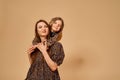 Two beautiful young girls sisters in nice animal pattern dresses with straw hats posing in studio Royalty Free Stock Photo