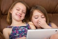 Two girls watching a tablet and laughing Royalty Free Stock Photo