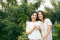 Two beautiful young well-dressed women chatting outdoors over co Royalty Free Stock Photo