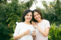 Two beautiful young well-dressed women chatting outdoors over co Royalty Free Stock Photo