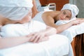 Two beautiful young woman having back massage. Front view. Tranquility. Royalty Free Stock Photo