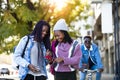 Two beautiful young woman using mobile phone in the street. Royalty Free Stock Photo