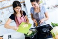 Two beautiful young women adding potatoes to the chards into the pan. Royalty Free Stock Photo