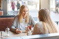 Two beautiful young women in a cafe