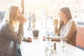 Two beautiful young women in a cafe