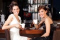 Two beautiful young women drinking coffee at bar Royalty Free Stock Photo