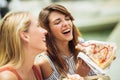 Two beautiful young women eating pizza after shopping Royalty Free Stock Photo