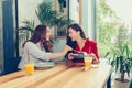 Two beautiful young women enjoying coffee and cake together in a cafe Royalty Free Stock Photo