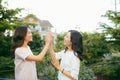 Two beautiful young women giving high five - Pretty girls standing on outdoors and having fun - Best girlfriends making a promise Royalty Free Stock Photo