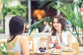 Two beautiful young women are having coffee and desserts together at outdoors cafe Royalty Free Stock Photo