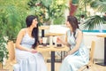 Two beautiful young women having a cup of coffee and desserts at cafe. Royalty Free Stock Photo