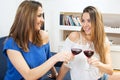 Two beautiful young women having fun drinking red wine together. Royalty Free Stock Photo