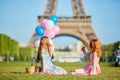 Two young women having picnic near the Eiffel tower in Paris, France Royalty Free Stock Photo