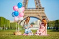 Two young women having picnic near the Eiffel tower in Paris, France Royalty Free Stock Photo