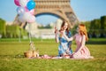 Two young women having picnic near the Eiffel tower in Paris, France Royalty Free Stock Photo