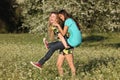Two beautiful young women piggy- backing in meadow Royalty Free Stock Photo