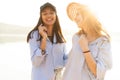 Two beautiful young women strolling on a beach. Female friends walking on the beach and laughing on a summer day. Royalty Free Stock Photo