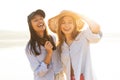 Two beautiful young women strolling on a beach. Female friends walking on the beach and laughing on a summer day. Royalty Free Stock Photo