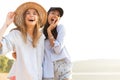 Two beautiful young women strolling on a beach. Female friends walking on the beach and laughing on a summer day. Royalty Free Stock Photo