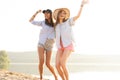 Two beautiful young women strolling on a beach. Female friends walking on the beach and laughing on a summer day. Royalty Free Stock Photo