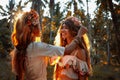 Two beautiful young woman in summer dresses outdoors at sunset