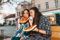 Two beautiful young women talking on mobile phone and eating pizza outdoors, having fun together Royalty Free Stock Photo